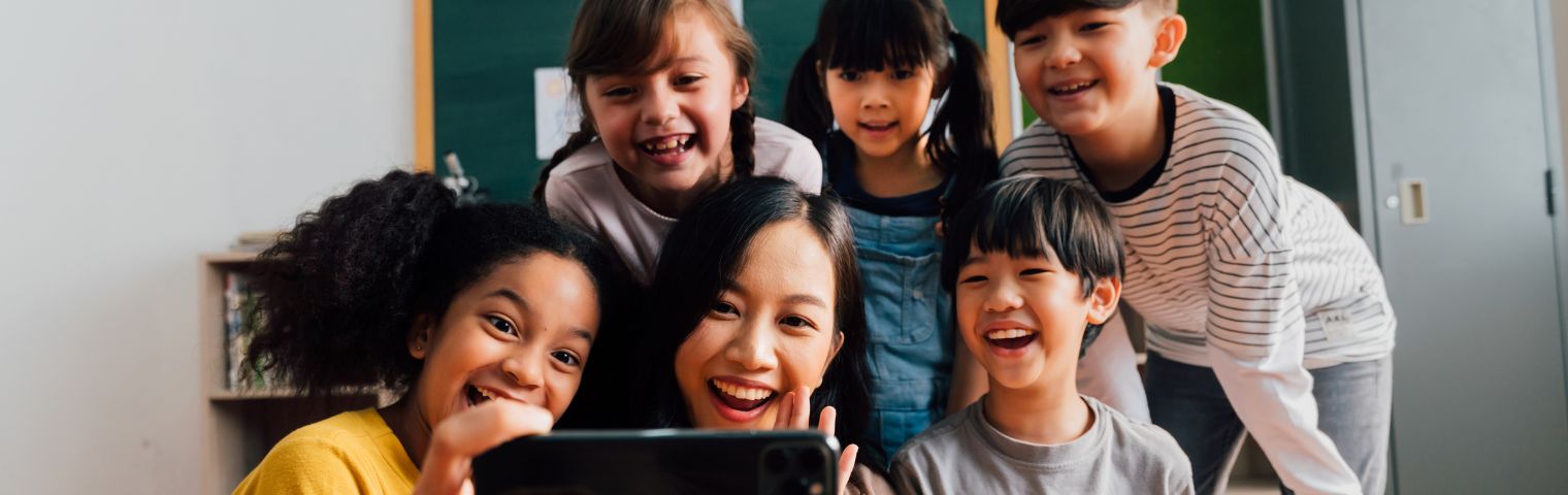 A bunch of kids smiling for a group selfie